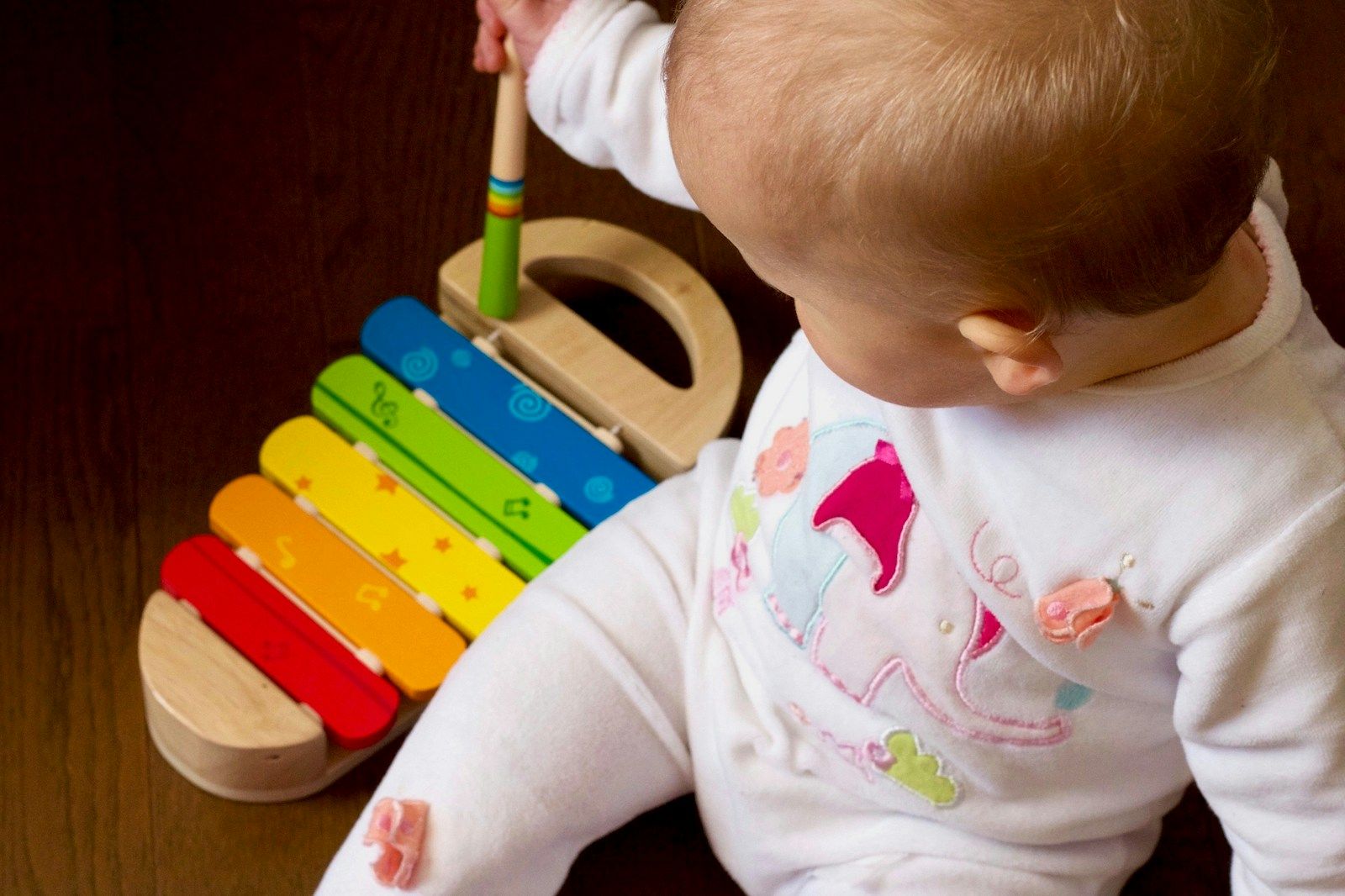 Relais Petite Enfance baby playing multicolored xylophone toy