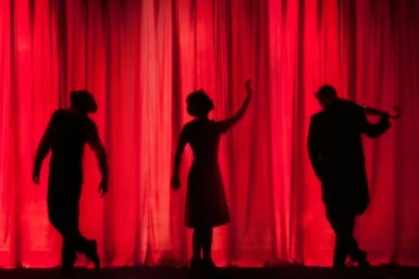 service culture silhouette of three performers on stage