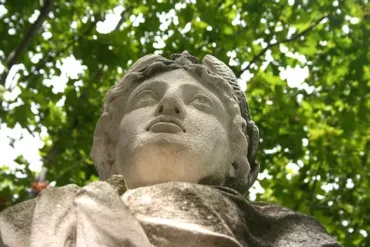 Photo en contre-plongée capturant la tête majestueuse de la statue de Marianne, symbolisant la République avec élégance et grandeur.