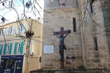 Une croix en bronze, symbole de la foi chrétienne, orne le mur extérieur de l'église.