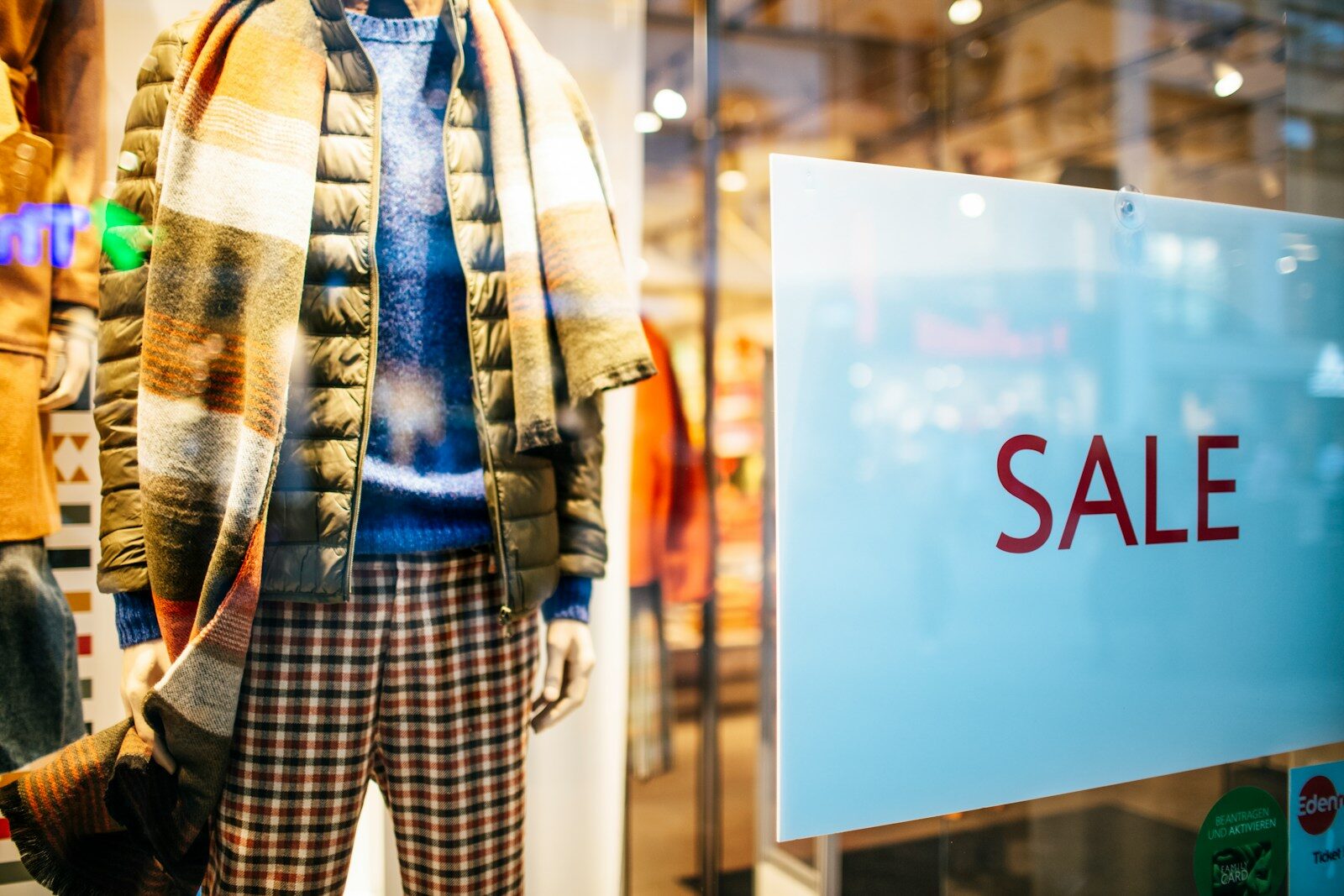 a mannequin in a window display with a sale sign Grande braderie des commerçants