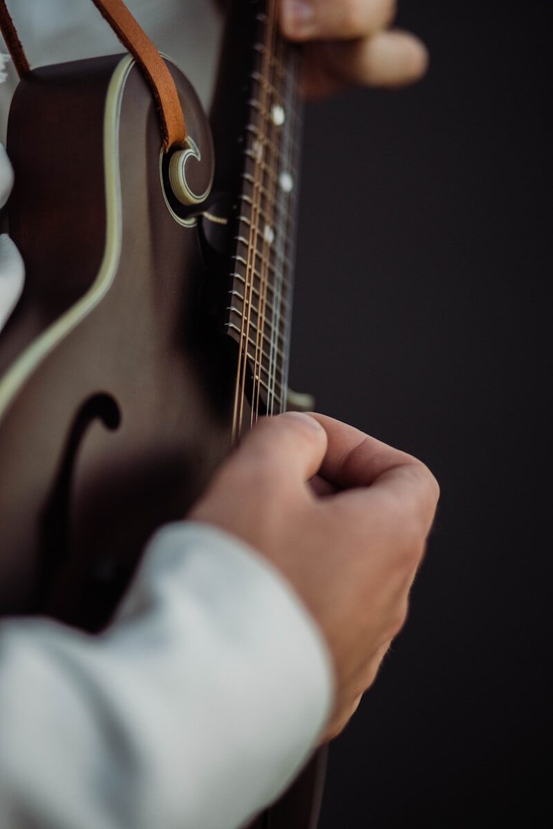100% Oïa a close up of a person playing a guitar