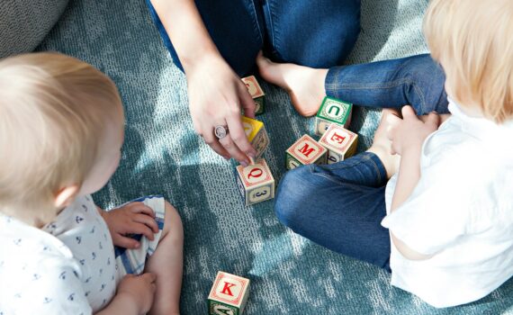 two toddler playing letter cubes