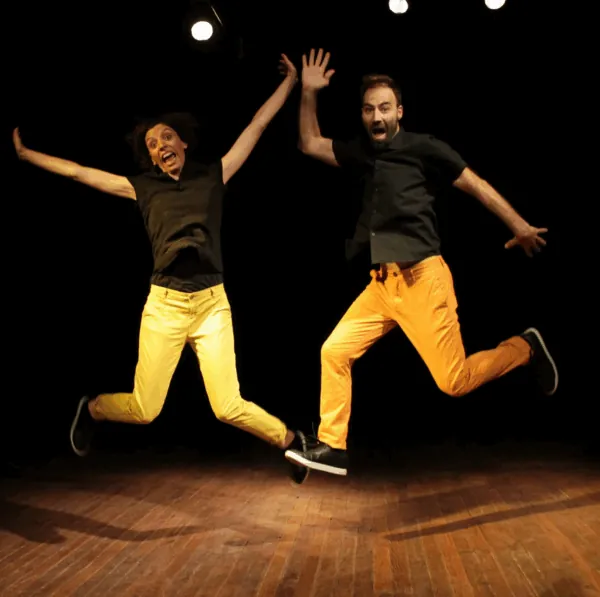 beep 2 acteurs qui sautent en l'air vêtus d'un pantalon jaune et d'un haut noir